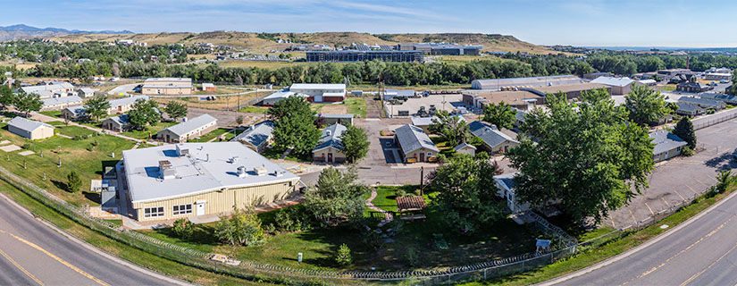 Drone view of a series of buildings with mountains in the background.
