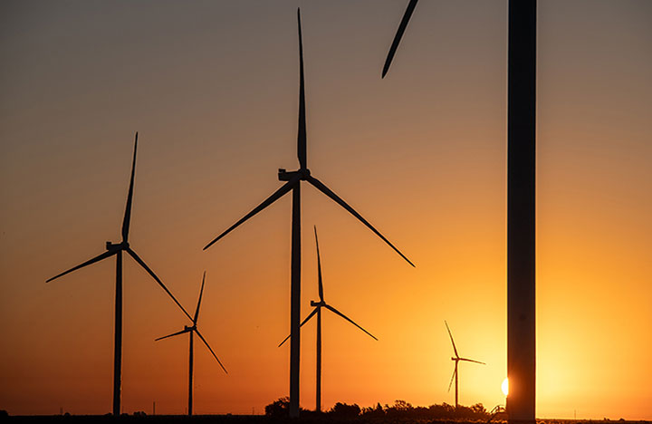Wind turbines in a field during sunset
