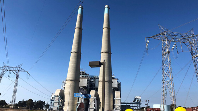 Power plant towers against blue sky.