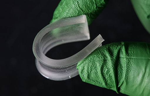 Two fingers bending a rubbery polymer