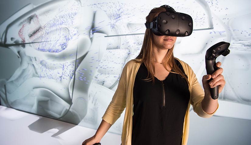 NREL Intern Alyssa Boll looks at a 3D rendering of ventilation in a car in the 3D Visualization Lab at NREL.