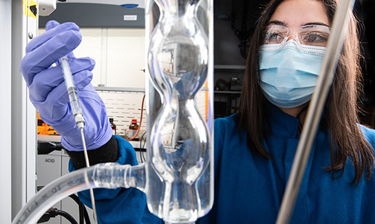 Researcher adding a substance to an experiment.