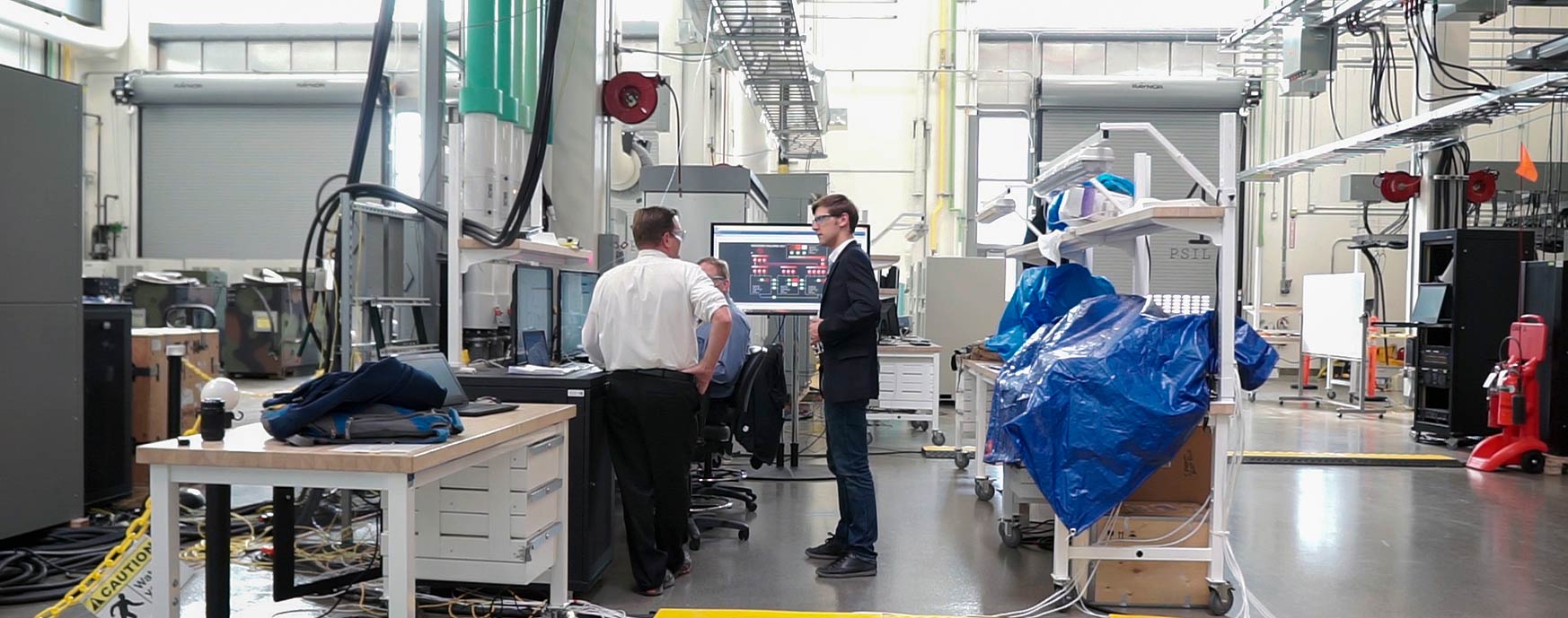 Researchers talking in NREL's Power Systems Integration Lab