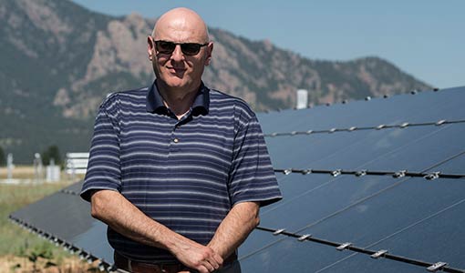 Researcher in front of solar panel.