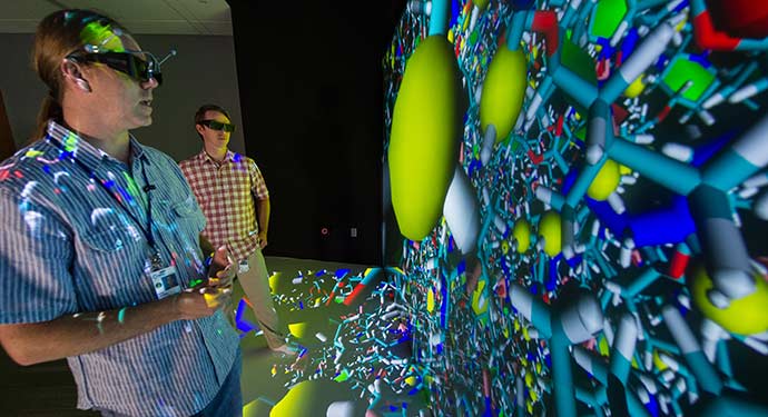 A photo of two researchers examining a colorful 3D molecular model.