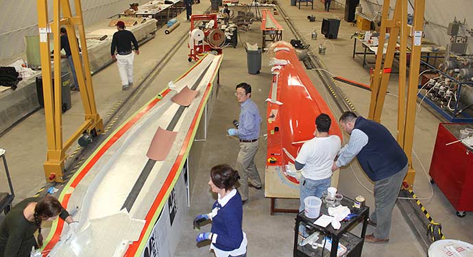 A birds-eye view of a large manufacturing facility, with people performing various activities across the image.