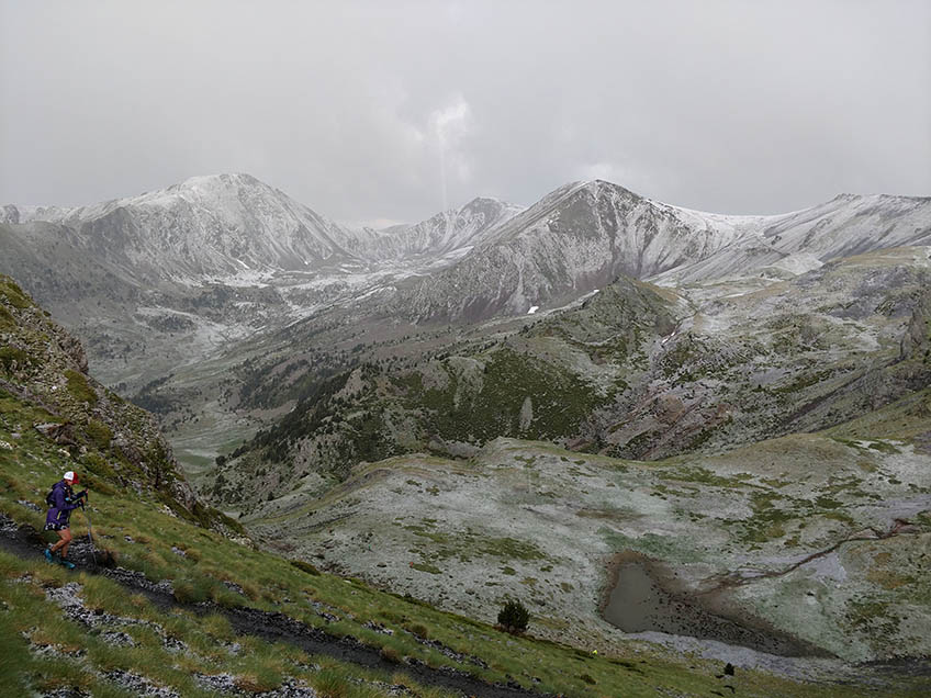 A woman runs on a mountain trail.