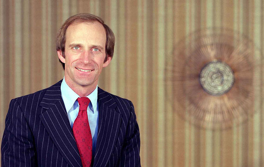 A man poses for a photograph in an office