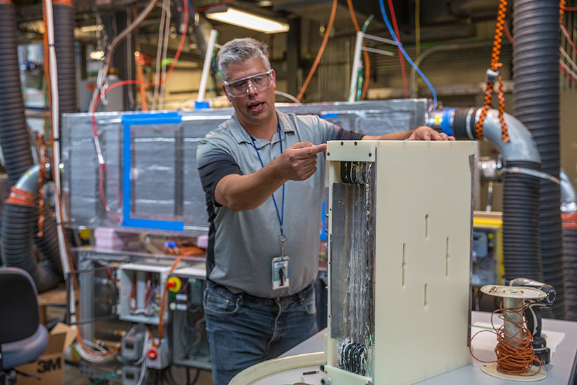 Photo of a researcher working with HVAC equipment in a lab