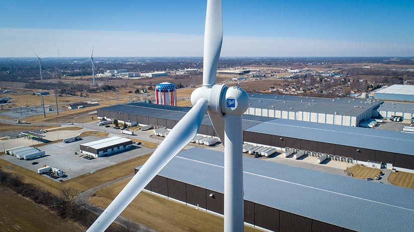 Wind turbine in the foreground with a small town in the background