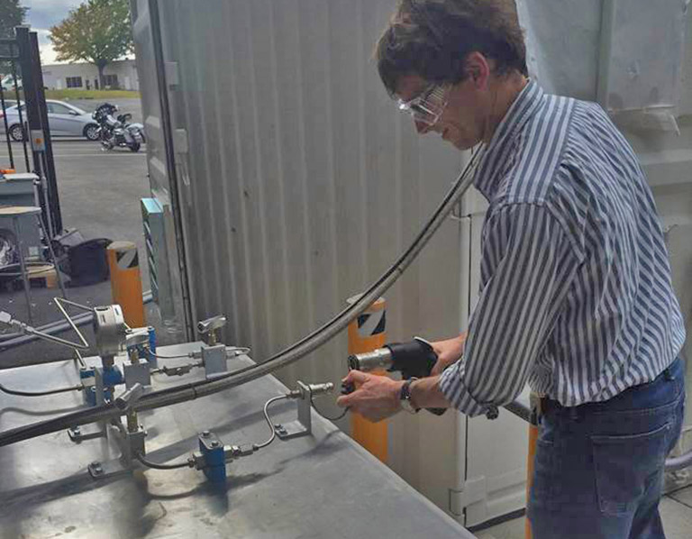 A man attaches a hydrogen nozzle to a receptacle.