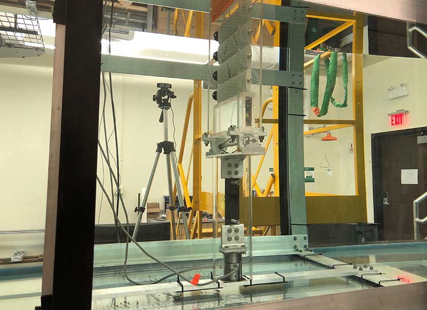 Side view of a wave energy converter above a wave tank