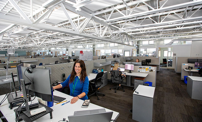 A person sitting at a desk in a well-lit, spacious office.