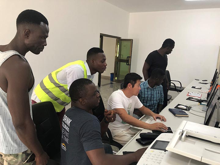 Five BPA technicians and control room operators looking computers to monitor the output of the new PV system.