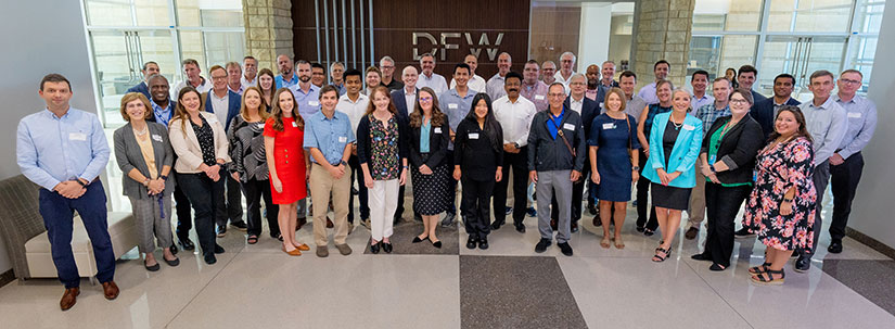 A group pf people pose for a photo at DFW airport.