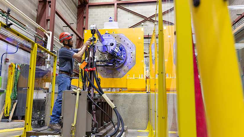 Person tests marine energy components on machine inside lab