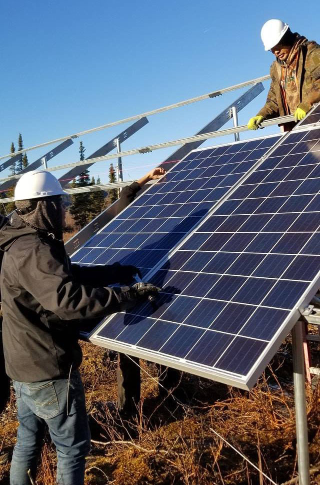 two people install a solar panel
