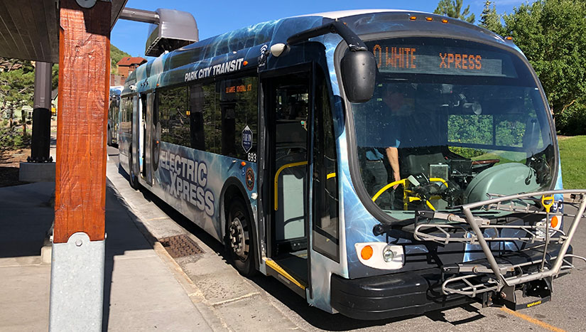 An electric public transportation bus at a bus stop.