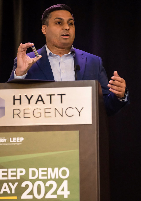A man speaking behind a podium. 