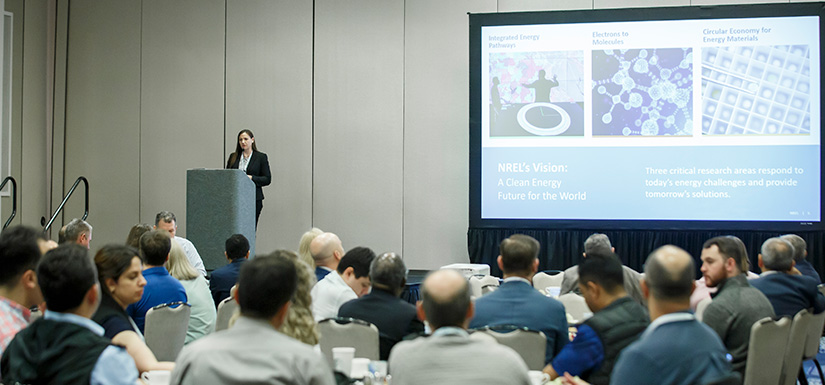 A woman on a stage speaking to an audience.