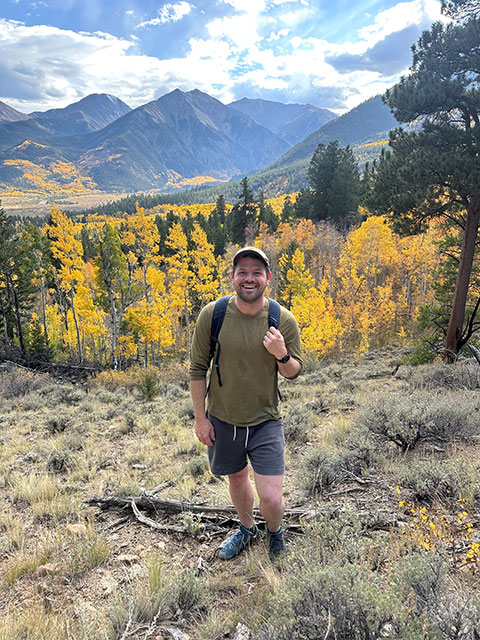 Jeremy Stefak hiking in front of mountains