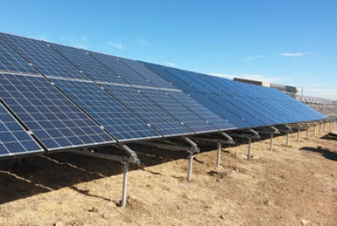 Photo of blue solar panels mounted on the ground.