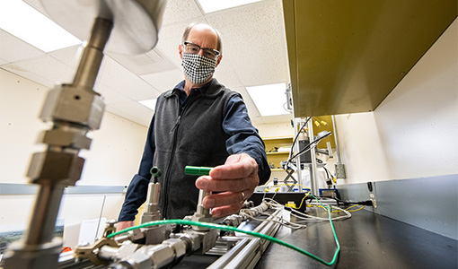 A researcher adjusting lab equipment.