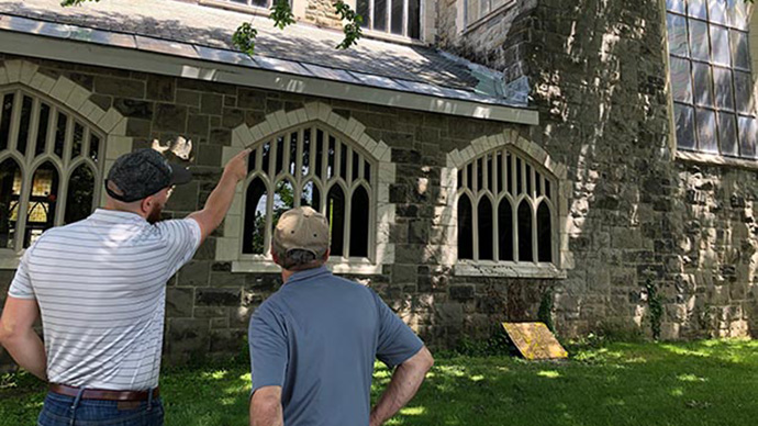 A photo of people pointing to an historic building in Cohoes, New York