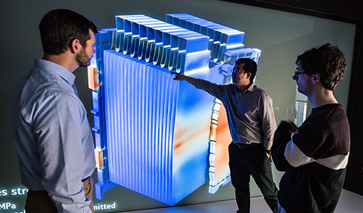 Three researchers review a graphic rendering of a 3-D battery. 