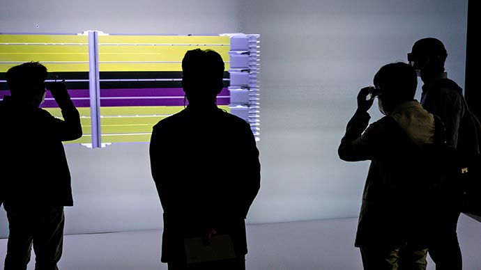 Researchers examine a wall-size, 3D virtual image of battery materials.