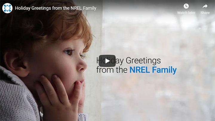 A young child looks out a window at the snow in a video.