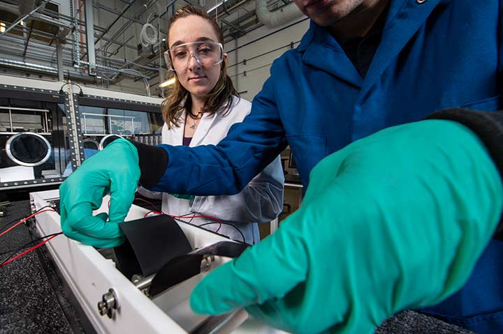 Two researchers working with scientific equipment in a laboratory setting