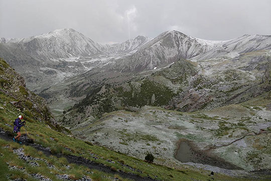 A woman runs on a mountain trail.