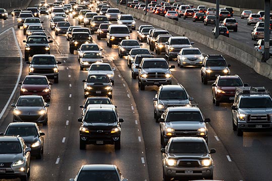 Cars sit in traffic on a busy highway.