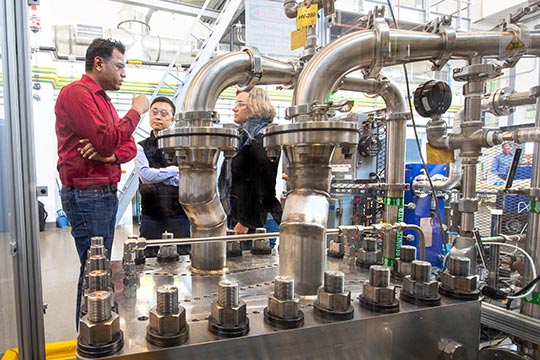 People standing behind machinery.