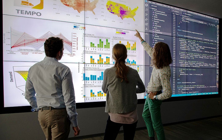 Researchers looking at a digital map.