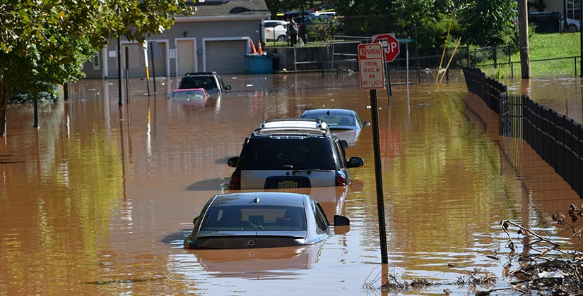 Cars parked on a severely flooded street.