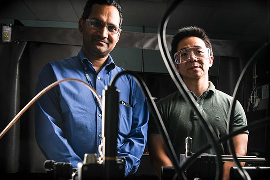 Two men stand in a laboratory.