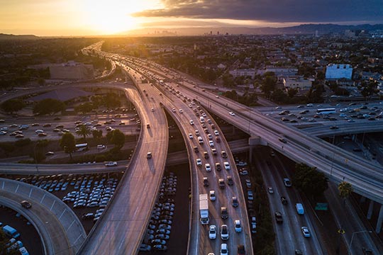 A highway system with traffic on one side at sunset.