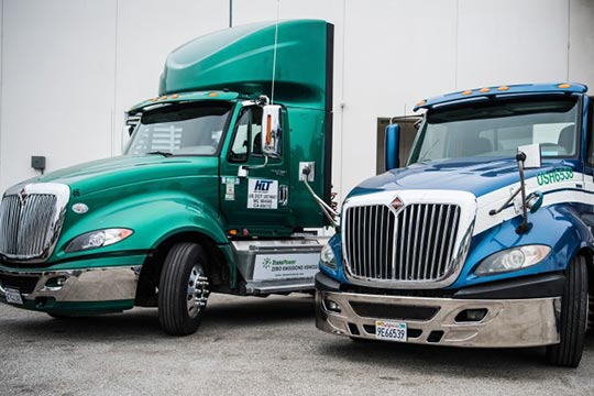 Two electric semi-trucks parked next to each other.