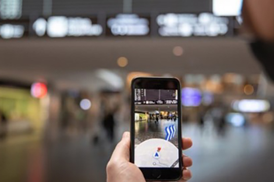 A person holding a phone in an airport.