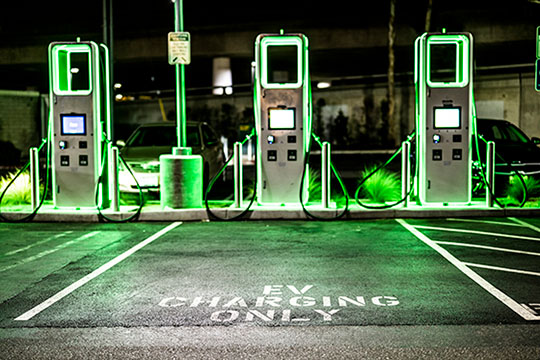 Electric vehicle charging station at night.