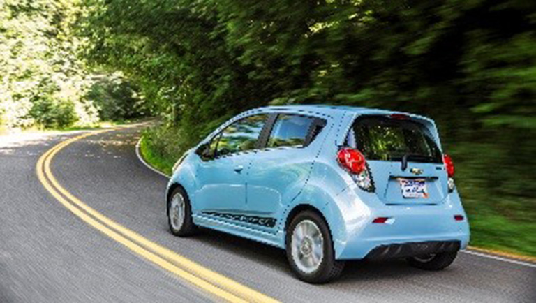 Photo of a car driving on a road through the forest
