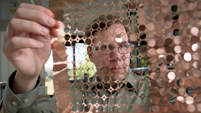 Photo of a researcher works with a plug flow reactor in a lab