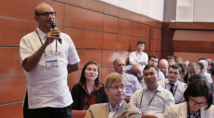 Photo of a man speaking into a microphone from the audience at the Asia Clean Energy Forum.