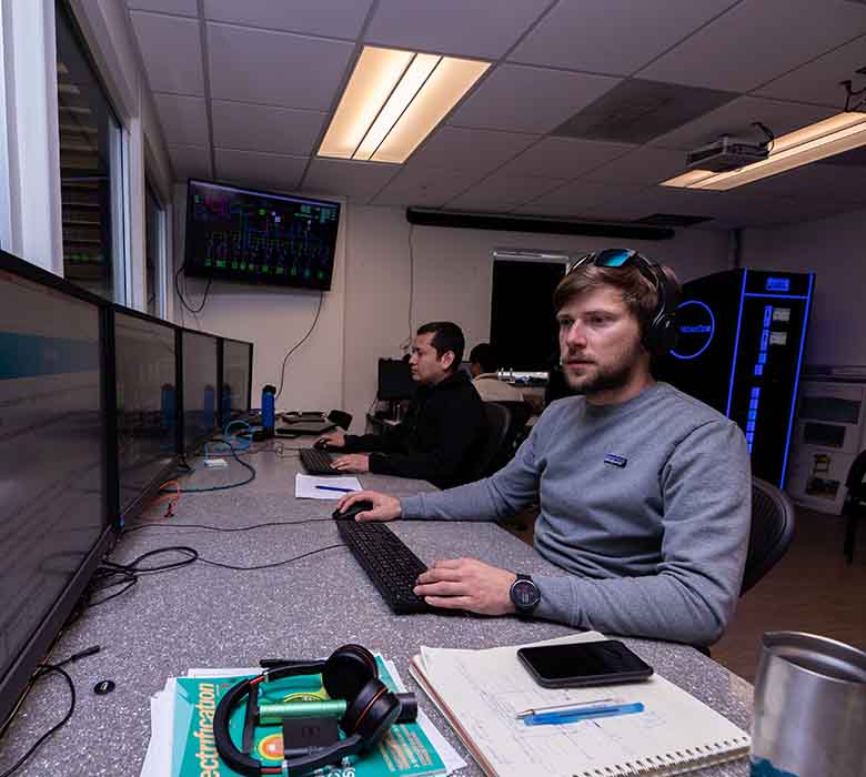 A man sits in the control room of the the 5-MW dynamometer at NREL's Flatirons Campus