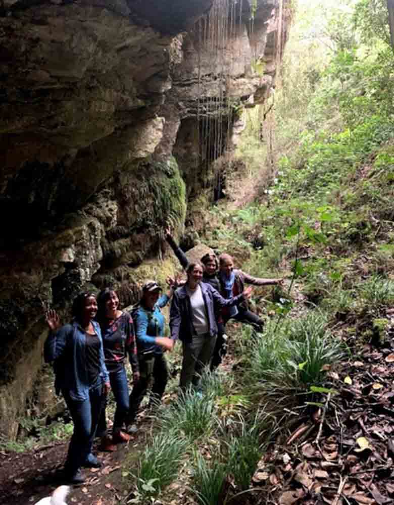 People on a trail next to a rock face
