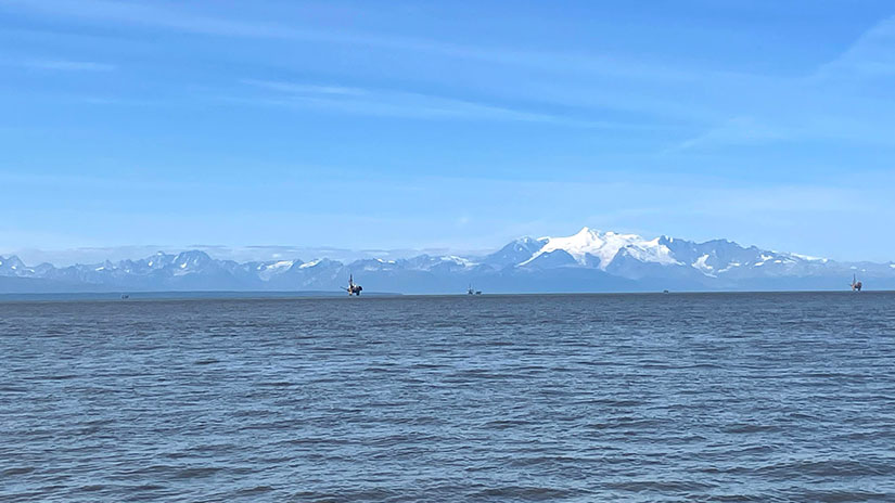 View of inlet water in Alaska with wind turbines in distance
